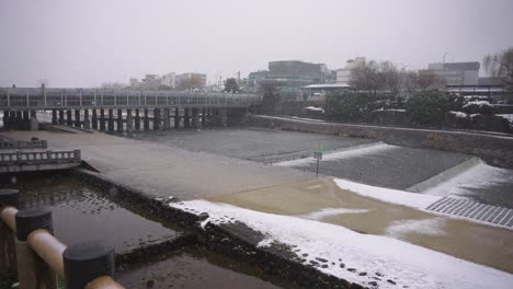 Kamogawa-Bridge-under-repairs-in-the-snow,-Winter-Day-in-Kyoto-Japan