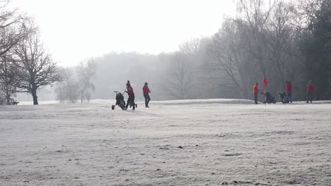 London,-England---January-22-2023:-Golfers-putting-on-a-frost-covered-golf-course-in-winter
