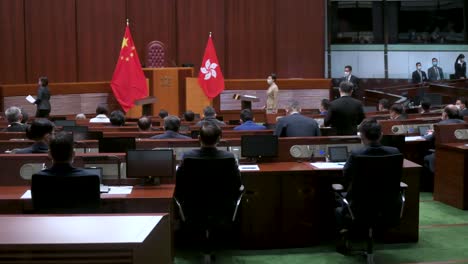 Former-Hong-Kong-Chief-Executive-Carrie-Lam-presides-over-the-oath-taking-ceremony-as-she-stands-next-to-the-People's-Republic-of-China-and-Hong-Kong-flags-at-the-Legislative-Council-main-chamber