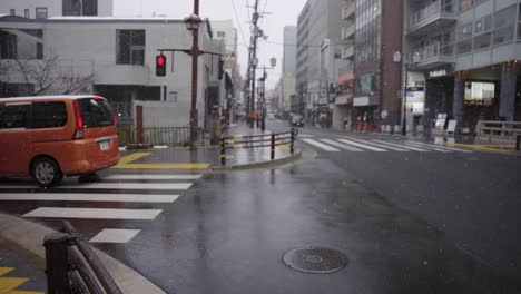 La-Nieve-Cae-En-El-Distrito-De-Sanjo-De-Kyoto,-Los-Coches-Circulan-Por-La-Ciudad-Mojada