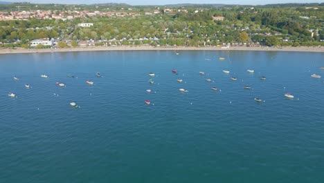 Aerial-orbit-around-boats-on-Lake-Garda-in-Italy
