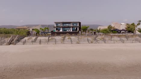 Aerial-view-of-a-villa-build-in-front-of-the-sandy-beach-in-southern-France-