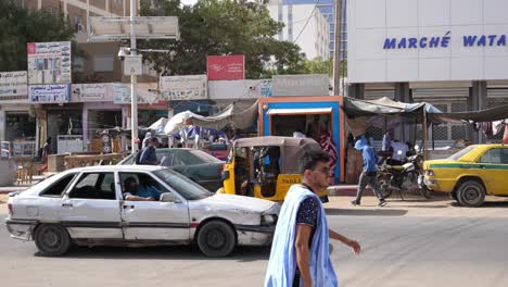 Street-Life-in-Downtown-Nouakchott,-Mauritania,-Traffic,-Cars,-Shops-and-People