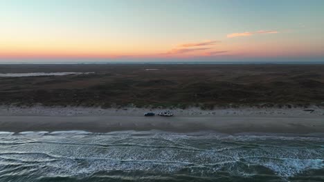 Sunset-Scenery-At-The-Beach-In-Padre-Island,-Texas-With-RV-Parked-On-The-Shore---aerial-drone-shot