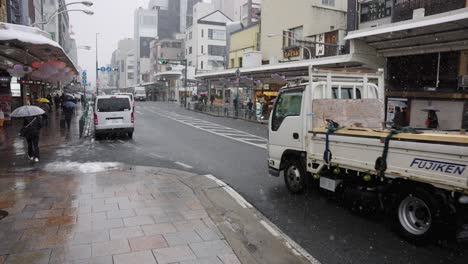 Central-Kyoto-Area-at-Gion-Shijo,-Snow-Falling-over-Streets-on-Winter-Day