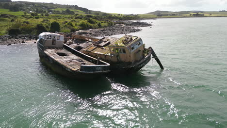 Aerial-rotating-view-of-an-old-and-abandoned-shipwreck-on-the-coast-of-Bluff,-New-Zealand
