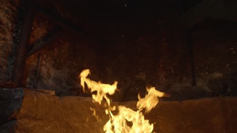 Fire-flame-rising-in-a-stone-fireplace,-slow-motion