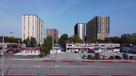 Toronto-Transit-Commission-bus-driving-in-bus-lane-in-front-of-strip-mall-stores-and-apartment-buildings