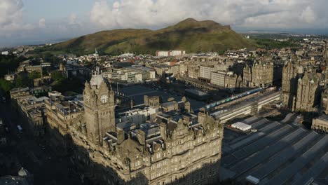 Aerial-view-of-Edinburgh,-Scotland-featuring-The-Balmoral,-Waverley-Train-Station,-and-Calton-Hill