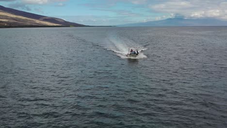 White-boat-speeding-on-calm-ocean-Molokai,-backward-rising-aerial