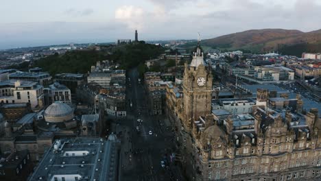 Orbiting-aerial-shot-of-an-old-clock-tower-in-Scotland's-capital-city-of-Edinburgh