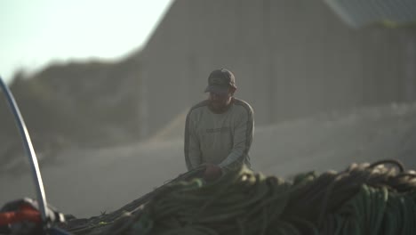 Fischer-Bereitet-Fischernetze-Vor,-Die-Von-Morgenlichtern-In-Zeitlupe-Sonnengeküsst-Werden