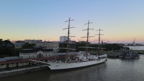 Aerial-Dolly-In-Ara-Libertad-Segelschiff-Angedockt-In-Puerto-Madero-Pier-Bei-Sonnenuntergang,-Buenos-Aires