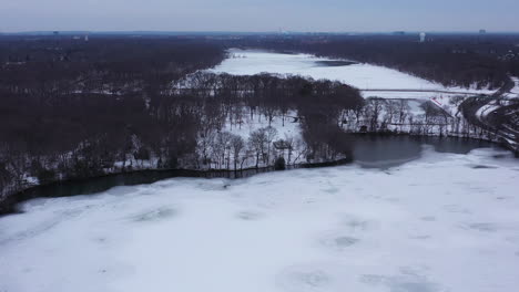 An-aerial-view-from-a-drone,-over-a-frozen-lake-during-sunrise-on-a-cloudy-morning