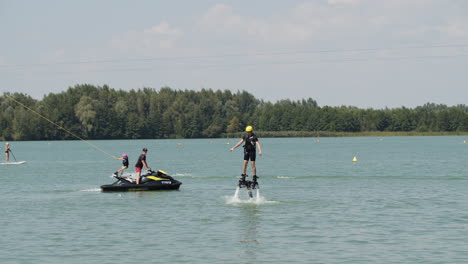 Plano-General-De-Flyboarder,-Esquiador-Acuático-Y-Persona-En-Stand-Up-Paddle-Están-Activos-En-El-Lago-En-Verano