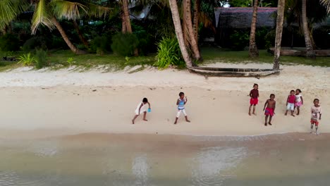 Afrikanische-Kinder-Laufen-Am-Strand-Von-Madagaskar-Entlang-Und-Jagen-Drohnen