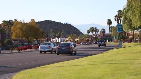 La-Quinta,-California-city-lane-traffic,-roadside-ornamental-greenery-and-trees