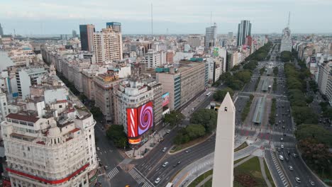 Antena-A-La-Derecha-Del-Obelisco-En-Plena-Avenida-9-De-Julio-Estación-De-Tráfico-Y-Metrobus,-Buenos-Aires