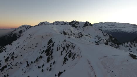 Summit-of-the-French-Alps-at-Chamrousse-during-early-sunrise,-Aerial-flyover-shot