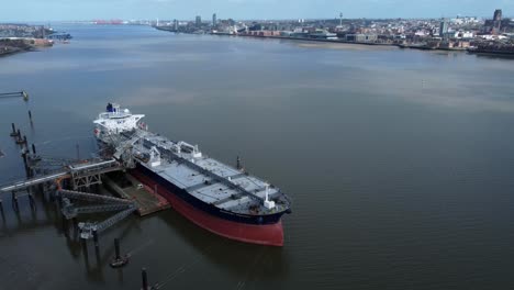 Crude-oil-tanker-ship-loading-at-refinery-harbour-terminal-aerial-tilt-down-overview