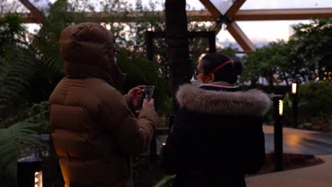 Two-people-standing-inside-Crossrail-Place-Roof-Garden-in-Canary-WHarf-wearing-face-masks