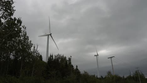 Zwei-Windturbinen-Produzieren-Strom-In-Der-Nähe-Einer-Stromleitung
