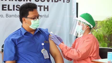 Yogyakarta,-Indonesia---15-De-Febrero-De-2021:-A-Los-Trabajadores-Sanitarios-Masculinos-En-Un-Hospital-Se-Les-Está-Inyectando-La-Vacuna-Contra-El-Virus-De-La-Corona