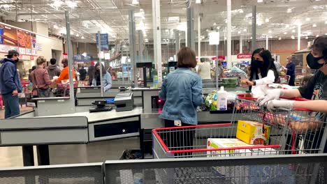 Costco-essential-worker-female-wearing-face-mask-scanning-the-grocery-items-of-the-customer