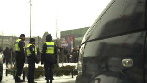 Eine-Gruppe-Von-Polizisten,-Die-An-Einem-Kalten,-Verschneiten-Tag-In-Der-Nähe-Von-Demonstranten-Auf-Dem-Citizen-Square-In-Helsinki-Stehen