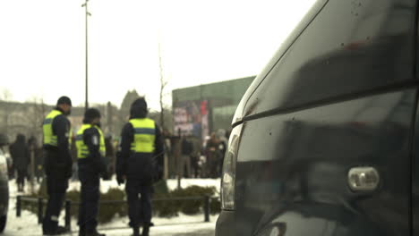 A-group-of-police-officers-standing-near-protesters-at-citizen-square-Helsinki,-cold-snowy-day