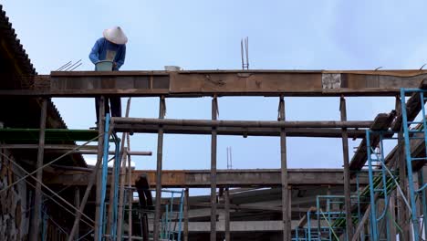 Roofer-nailing-wooden-roof-construction,-building-industry-worker-in-Indonesia