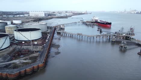 Aerial-view-International-oil-tanker-docked-at-refinery-loading-terminal-pier-depot-pan-left
