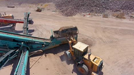 Toma-Cinematográfica-De-Drones-De-Una-Excavadora-Cargando-Rocas-En-Una-Cinta-Transportadora-En-Una-Cantera-De-Roca