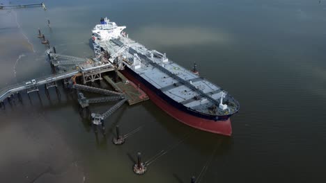 Crude-oil-tanker-ship-loading-at-refinery-harbour-terminal-aerial-view-orbit-left