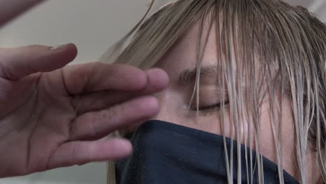 A-blond-lady-having-her-fringe-trimmed-in-a-hair-salon