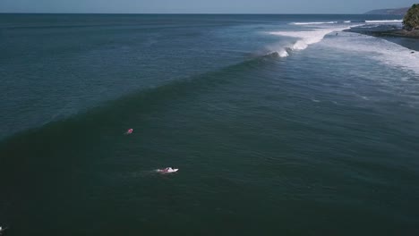 Surfers-attempt-to-ride-large-waves-in-the-shores-of-the-Cocal-Beach-in-La-Libertad,-El-Salvador