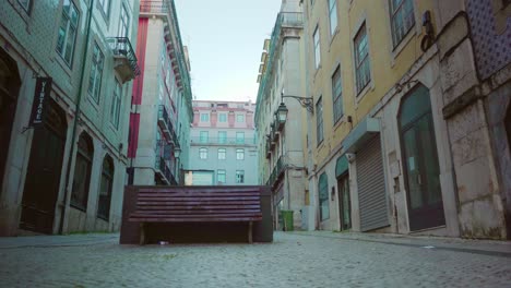 Centro-De-La-Ciudad-De-Lisboa-Vacío-Con-Banco-Público,-Fachada-De-Edificios-Antiguos-Durante-El-Cierre-De-Covid-19-Al-Amanecer-4k