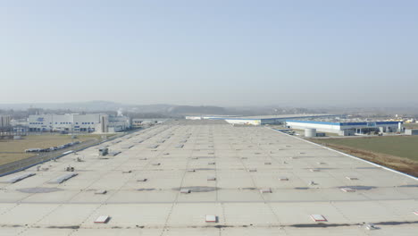 Aerial-Flyover-Of-A-Distribution-Facility-Rooftop-Located-By-A-Airport-In-Czech-Republic