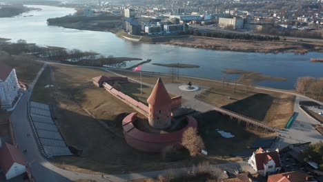 AERIAL:-Medieval-Kaunas-Castle-near-Nemunas-River-on-a-Sunny-Day-with-Waving-Flag