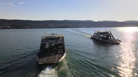 Aerial-drone-shot-following-two-car-ferries-crossing-each-other-on-Lake-Zürich-in-Switzerland