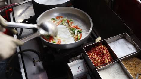 Professional-chef-prepares-white-sauce-Pasta-at-a-street-food-shop-at-Chat-Gali-in-Agra,-India-on-07-March-2021