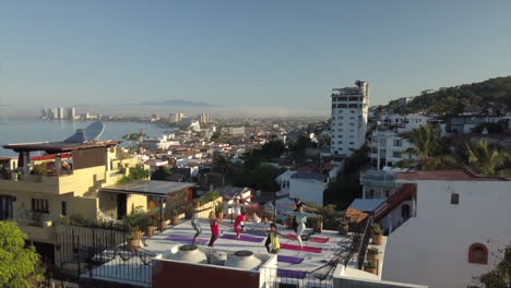 Woman-in-a-yoga-class-with-a-scenic-view-of-the-ocean-and-landscape---panning-aerial-view