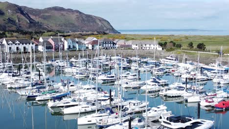 Luxury-yachts-and-sailboats-mooring-in-Conwy-Wales-colourful-sunny-mountain-marina-Aerial-view-dolly-right