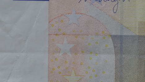 Dedo-Tocando-Billetes-Reales-De-Cincuenta-Euros-Con-Bandera-Europea-Y-Estrellas,-Plano-Macro