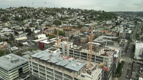 Tirando-Lentamente-Hacia-Atrás-Y-Revelando-Dos-Grúas-Torre-Que-Erigen-Un-Edificio-De-Gran-Altura-En-Seattle,-Aeroil