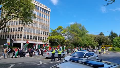 Tiro-De-Carro-Con-Coche-Garda-Irlandeses-Apoyando-Una-Protesta-Palestina-En-Dublín-Con-Carteles-De-Personas