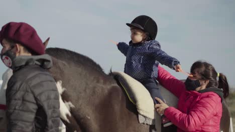 Animal-Trainers-Assists-The-Kid-On-Horseback-Riding-Activity-On-The-Ranch-In-Argentina