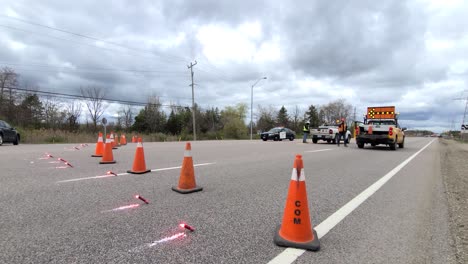 Policías-Y-Trabajadores-De-Seguridad-Bloquean-El-Tráfico-En-La-Carretera-Con-Bengalas-Y-Conos