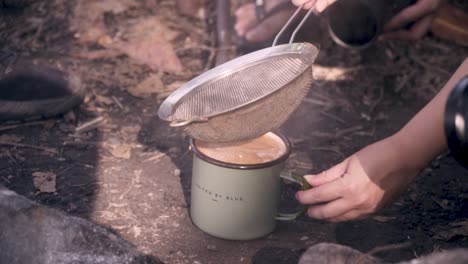 Straining-Hot-Chai-Tea-And-Pouring-Straight-Into-The-Mug-On-The-Campgrounds-Of-Pulau-Ubin,-Singapore