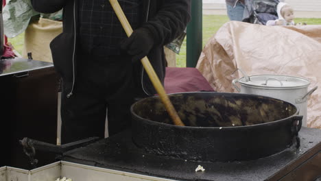 Persona-Cocinando-Una-Gran-Cuba-De-Comida-Callejera-En-Un-Festival---Dogwood-Festival-Siloam-Springs,-Arkansas,-EE.UU.